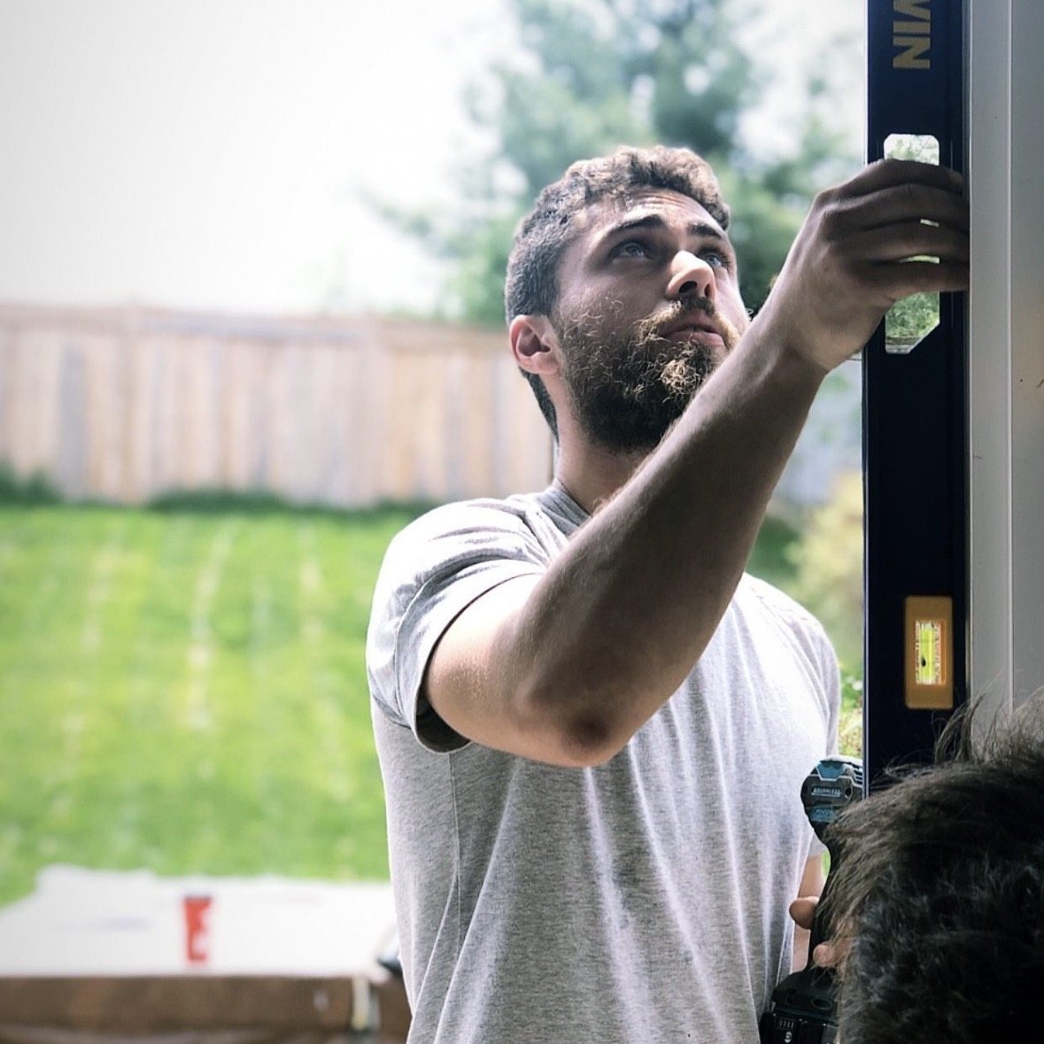 Dustin Kopman checking a door frame with a level