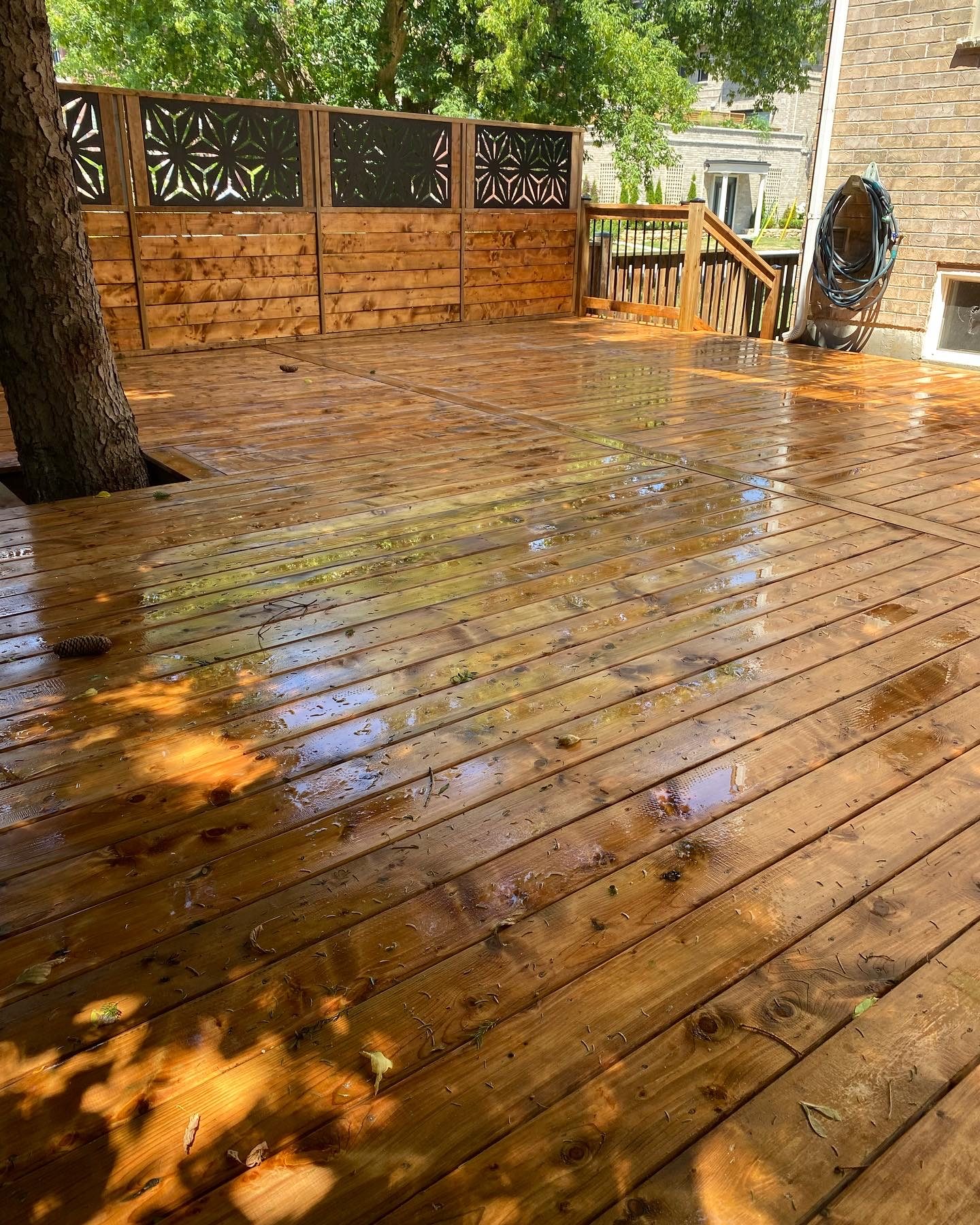 Refinished wood deck with decorative privacy screen and stairs in The Annex, Toronto, refinished by Kopman Build in 2023